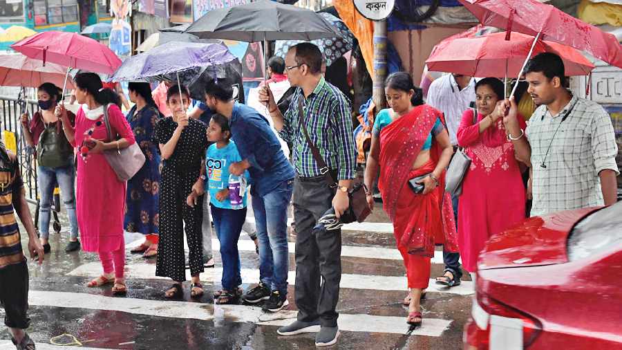 Pedestrians amid rain in Gariahat on Sunday. 