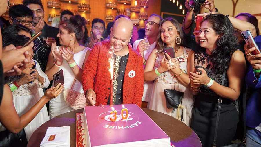 Sudarshan Chakravorty celebrates the feat by cutting a cake with his  well-wishers