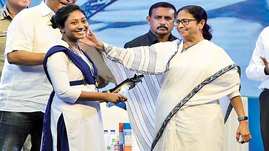 Mamata Banerjee with a girl after handing over an appointment letter to her at the Netaji Indoor Stadium in Calcutta on Monday.