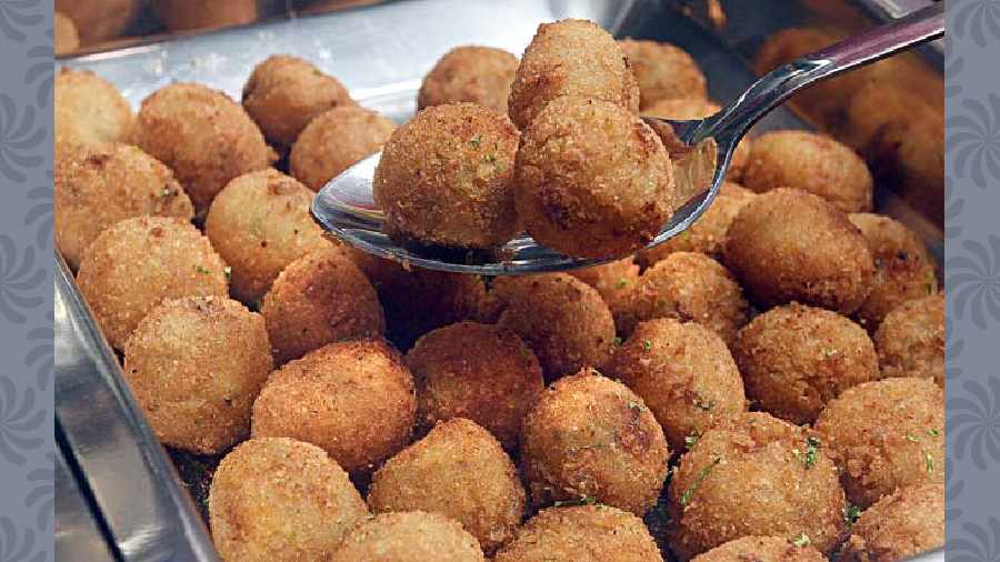 Jalapeno Cheese Balls: A perfect game-day snack, they are deep-fried, melted cheese balls stuffed with diced jalapenos and bacon, coated in crispy breadcrumbs.