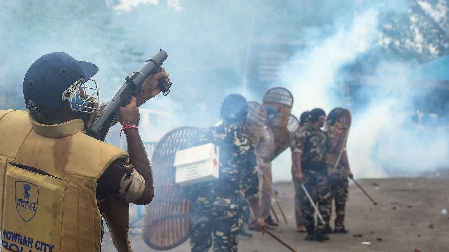 A security personnel fires a tear gas shell