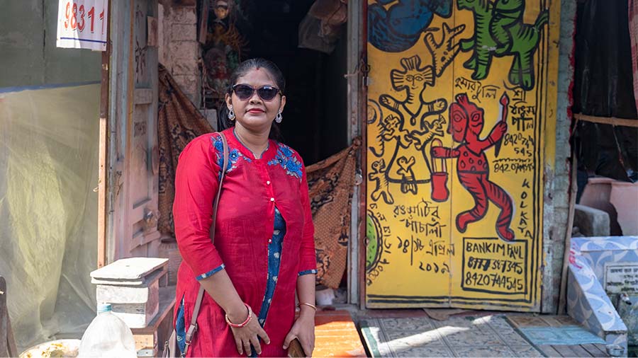 Jhulan Saha poses in front of a colourfully painted door in Kumartuli.