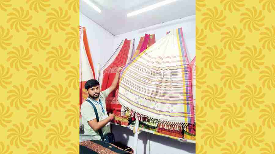 Bitan Biswas displays a white handloom sari with ikkat motifs at Taanter Haat.