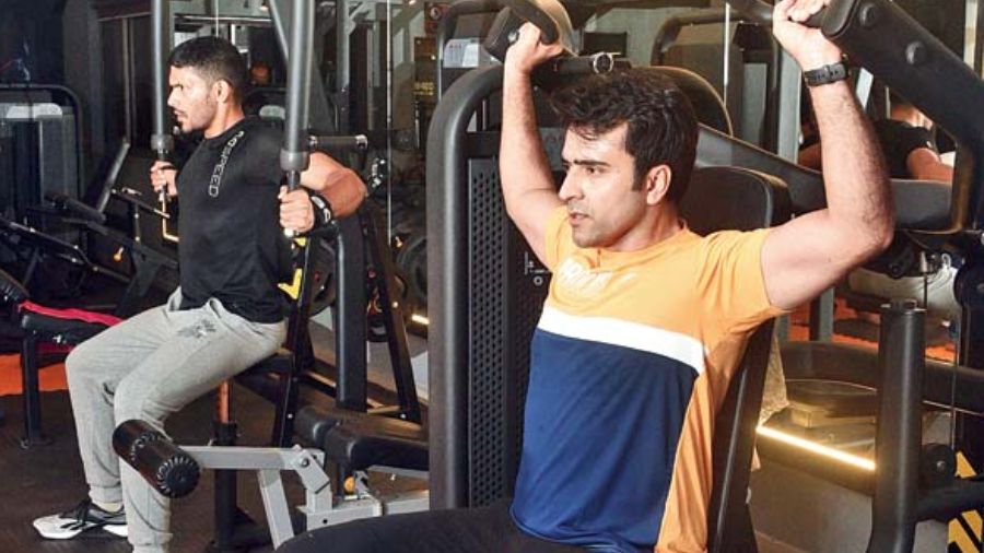 Abir sweats it off with a set of shoulder press as Arjun hits the pec deck