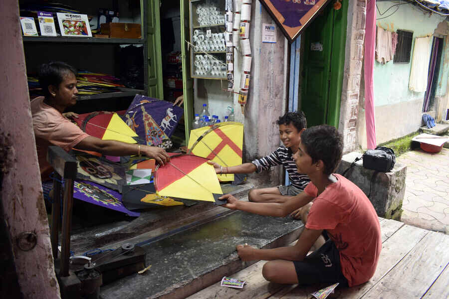 Kids negotiate with a kite seller at a shop in north Kolkata.