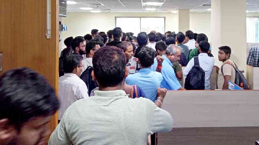 A group of CSIR-NET aspirants affected by the server glitch surround an observer (not visible) at the Taratala examination centre on Friday