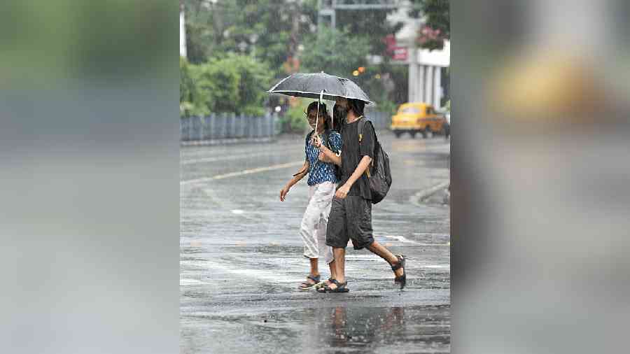 Pedestrians cross a street amid rain near Esplanade on Friday afternoon. 