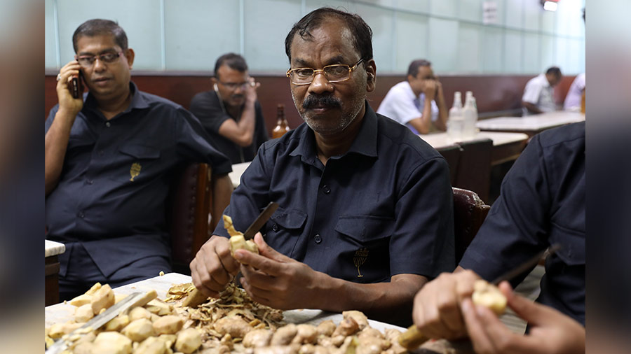 Harendranath Jana, the senior-most employee at Chhota Bristol, peels ginger for the customers’ favourite kancha chhola with aada 