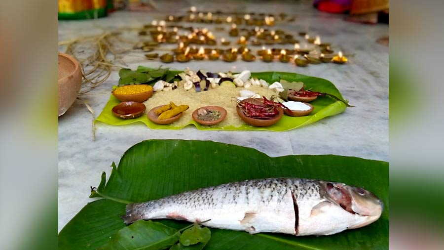 An uncooked fish with all its scales intact is offered to Goddess Durga on all days of the Puja 