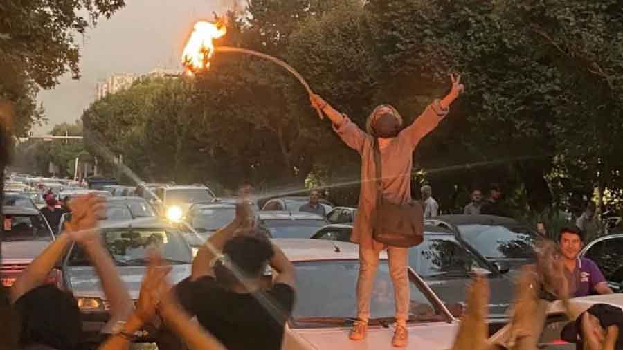 A woman burns a hijab in protest against the death of Mahsa Amini