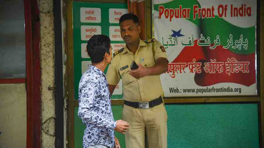 A security person keeps vigil outside the Popular Front of India (PFI) party office in Navi Mumbai