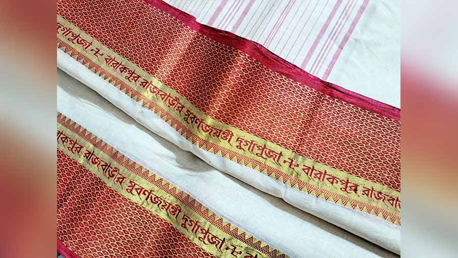 Tangail handloom sari with ‘Barrackpore Rajbari Subarnojayanti Durga Puja’ woven on the border that every woman in the family wears