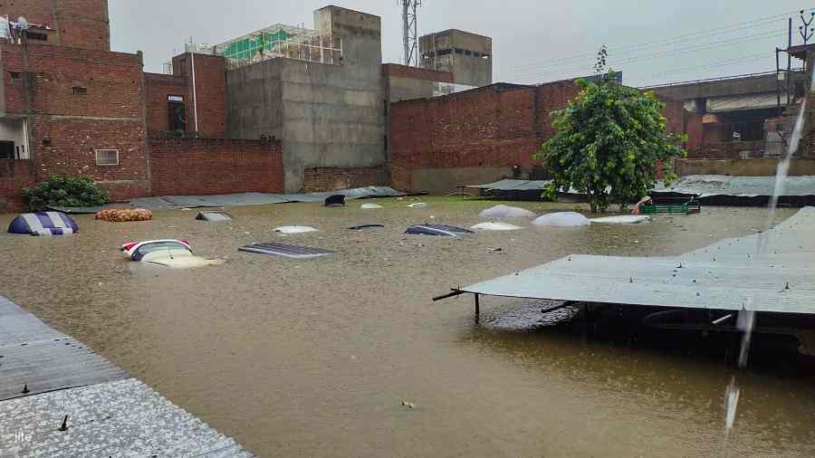 Vehicles submerged in flood water at a garage in Delhi