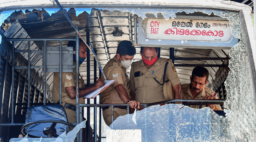 Police personnel take stock of the damages done to a Kerala State Road Transport Corporation bus in Thiruvananthapuram on Friday.