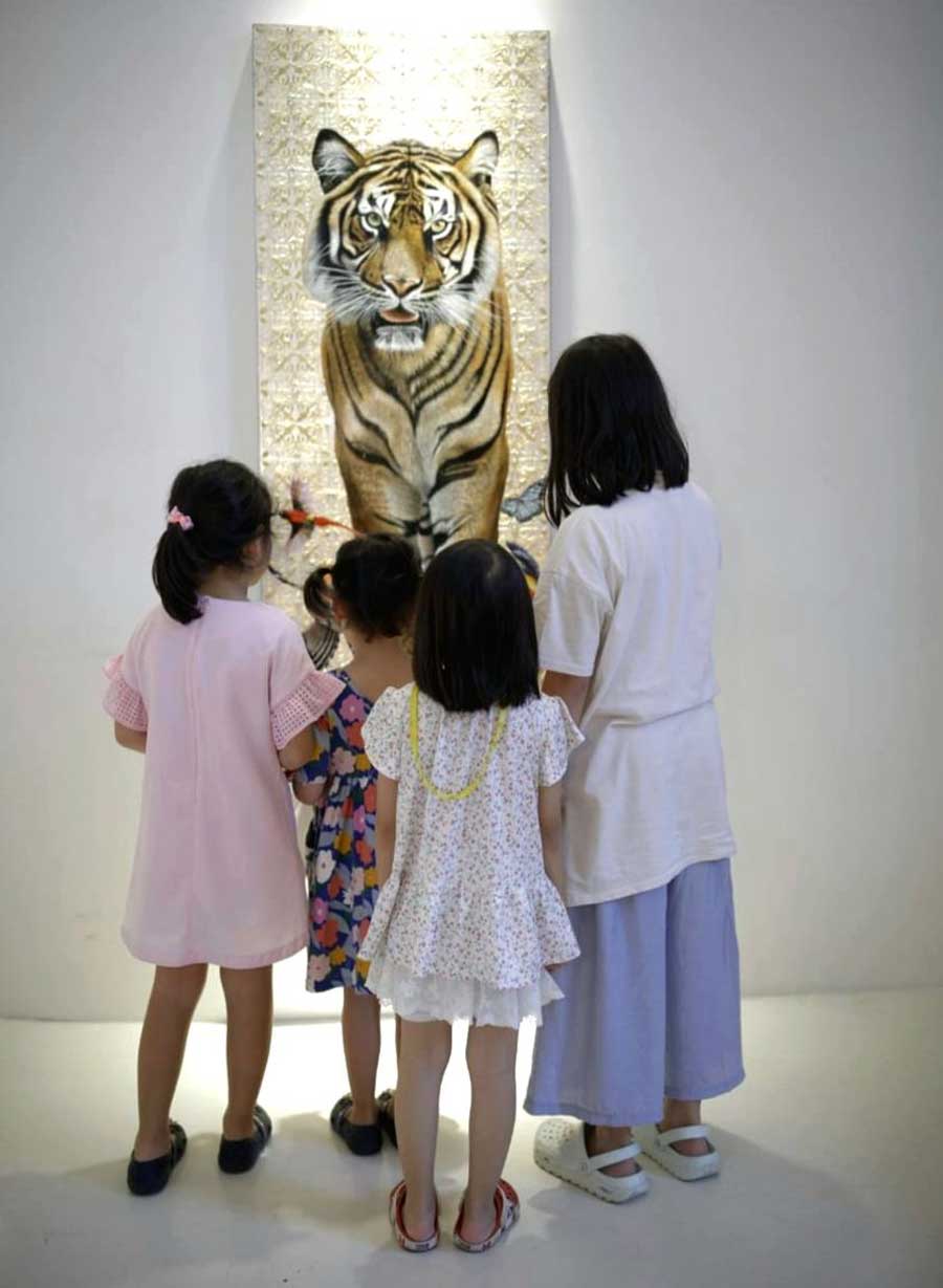 Children look at a painting of a Royal Bengal Tiger at an exhibition titled ‘Tigris: the Queen of Wildlife’ at Kolkata Centre for Creativity. 