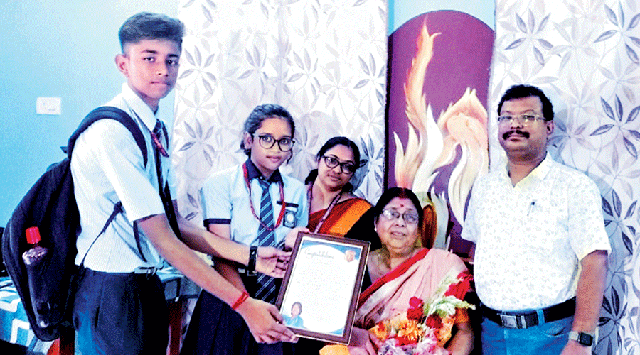 Students of Broadway Accent High School, Chakdah, hand over a memento to cricketer Jhulan Goswami’s mother Jharna Goswami (seated) at her home in Chakdah on Saturday.