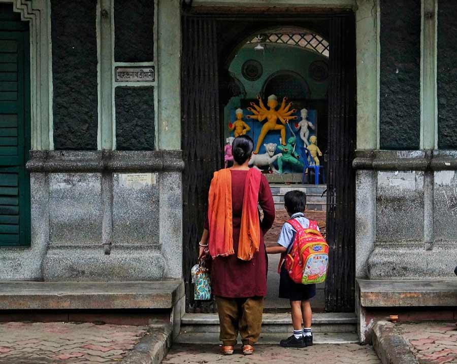 A school boy and his guardian look at an unfinished Durga idol of a traditional household puja in north Kolkata on Tuesday, September 20.  