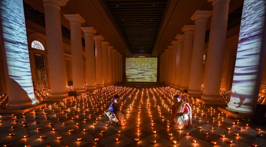 Women light traditional earthen lamps or pradips at an art installation-cum-exhibition showcasing the various aspects of Durga Puja at Town Hall on Thursday, 22. 