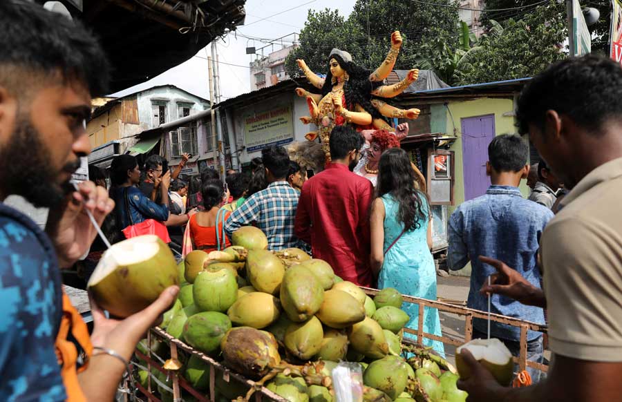 A group of people accompany a Durga idol on its way to the mandap. 