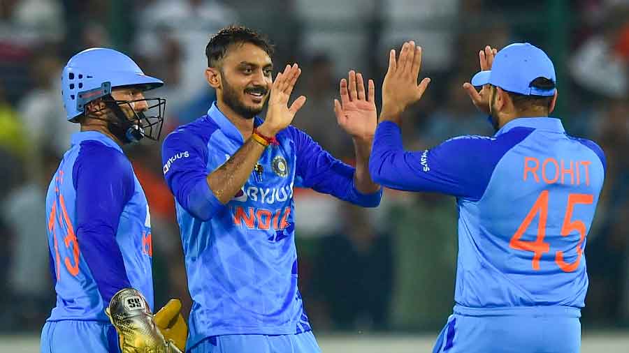 Axar Patel (M) celebrates fall of a wicket with Dinesh Karthik and skipper Rohit Sharma (R)