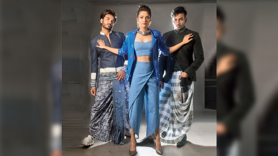 (L-R) Abhiroop sported an Abhishek Dutta ensemble. The linen handwoven distress denim bomber jacket was paired with a printed dhoti with denim detailing. Susmita donned a Kavya Singh Kundu outfit. A handwoven cotton bralette in natural indigo was paired with dhoti-style indigo pant with asymmetrical cuts. The look was styled with a handwoven cotton jamdani jacket in indigo, detailed with contrast stitch work and beads and silver jewellery from Earthaments.  Nishchay was styled in Abhishek Dutta. The checkered black-and-white dhoti with crochet border and leather pockets was teamed with a charcoal black bandhgala with leather detailing.
