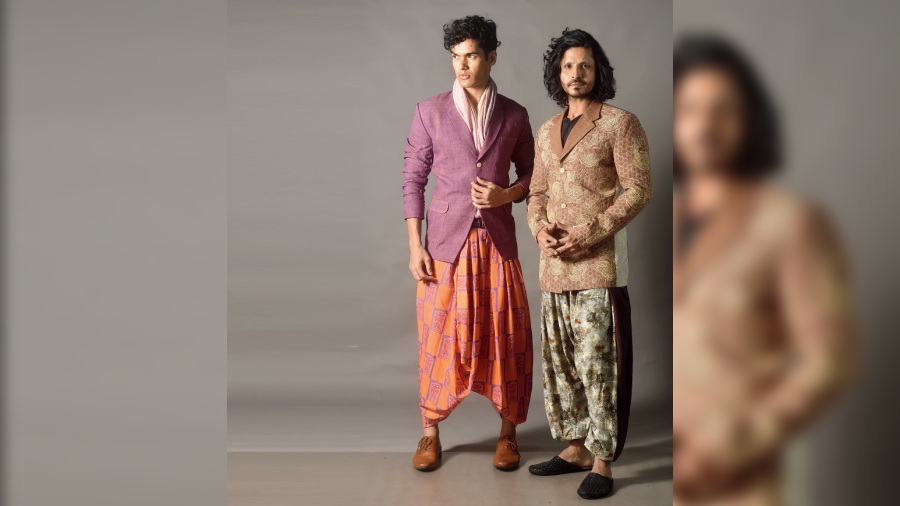 Rangeet Raheel (left) sported a cotton printed dhoti in vibrant festive shades of orange and purple, teamed with a purple linen lapel jacket and a soft kantha stole. If dhoti or pre-stitched dhoti is beyond your comfort zone, opt for this printed pannelled dhoti pants on Mohammad Shabbir Beig, paired with a brown embroidered linen lapel jacket on a black T-shirt. Both Outfits by Abhishek Dutta