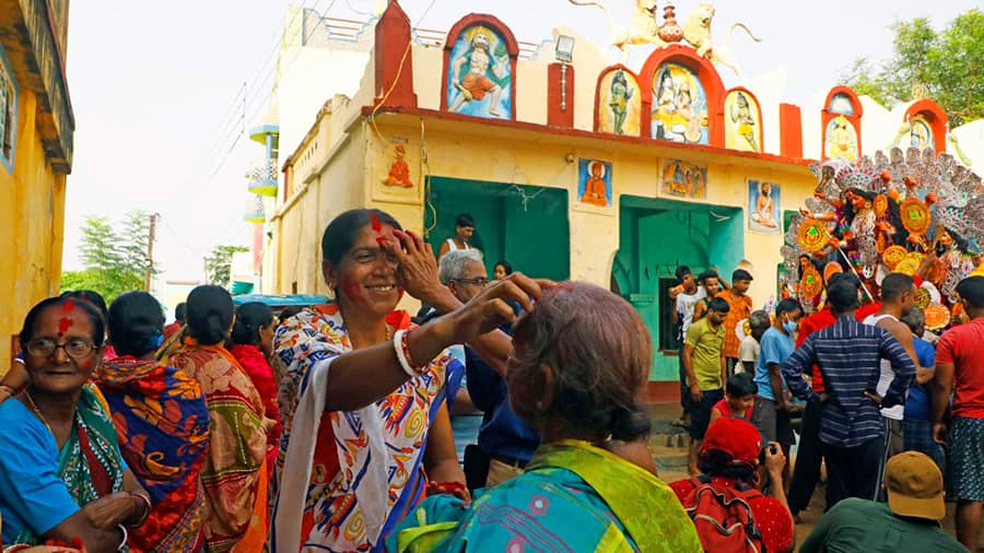 As the goddess gets ready for the bullock cart ride in front of the temple, women get busy with Sindoor Khela