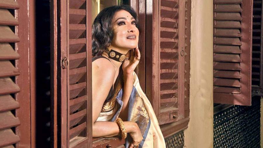 Rituparna’s life has been revolving around reels for over three decades now. Her look in the traditional silk gadwal sari, designed with a dual-shade border in black and grey with zari work, exudes a classic vibe resembling a frame taken straight from the reel of a classic Bengali film. The traditional statement choker and bangle add to this classy and classic Saptami look. Her hair is worn open in soft curls and the look is complemented with an overall contemporary-favourite nude colour palette on the face.