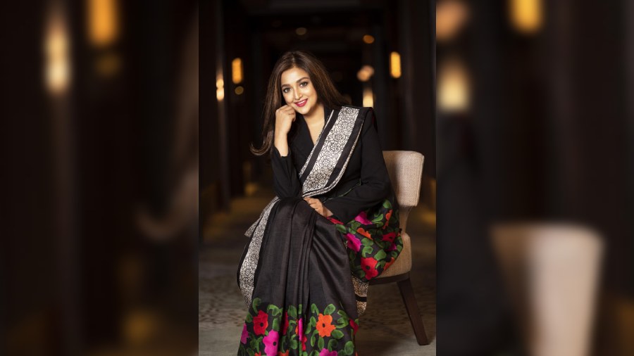 A frame exuding classy charm. Monali draped a black cocoon silk featuring a block-printed border and colourful handpainted floral motifs on the body.