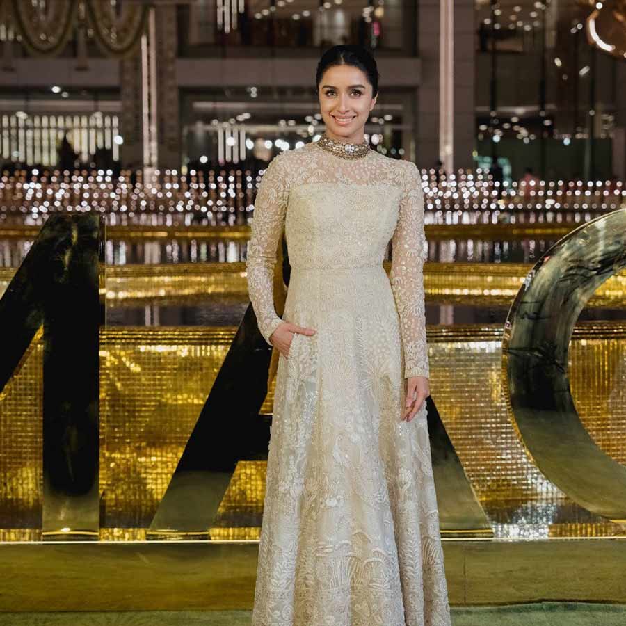 Shraddha Kapoor posed in a white lace gown with a gold choker necklace and slicked back bun. 