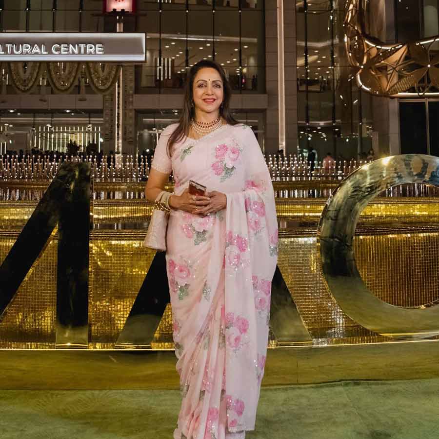 Hema Malini attended the event in a light pink sari with floral embellishments and a matching pink purse. 