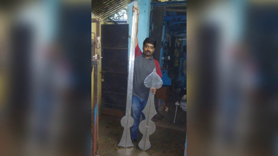 Satyajit Dutta stands with the two large hands that were finally installed on the dial of the Lake Town Clock Tower  