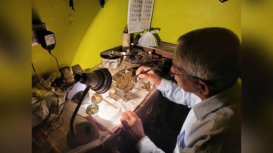 Swapan Dutta repairs a clock part in his one-room workshop  