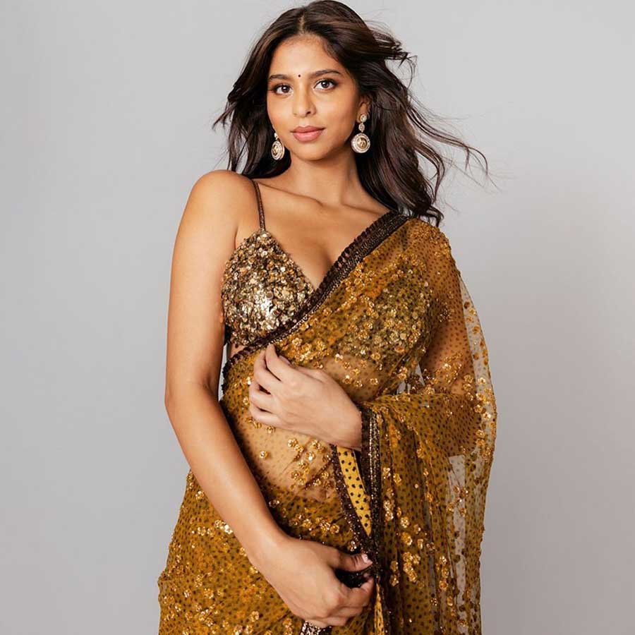 Suhana Khan kept it simple but glam in a sheer golden Sabyasachi sari paired with a shimmery bralette and danglers. 