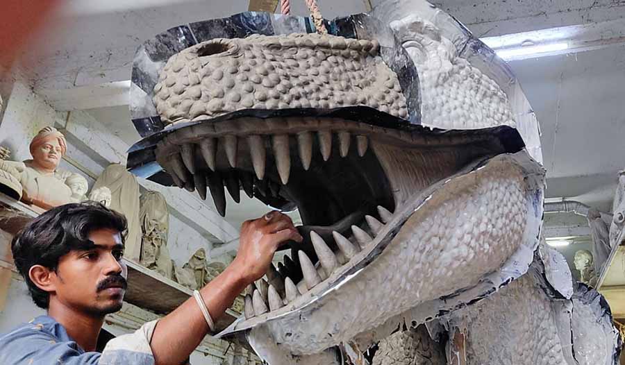 An artist at Monti Paul's studio at Kumortuli gives finishing touches to a Dinosaur model which will be installed in Jharkhand 