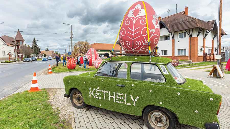 An installation imitating an Easter egg on display atop an old car in Kethely, Hungary, on Palm Sunday. 