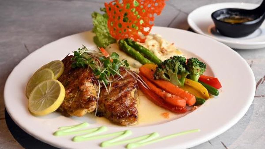 Grilled Basa Fillet with Lemon Butter Sauce: This continental classic fish dish has grilled fish marinated with cheese, served along with veggies, mashed potatoes and baked cheese crispy