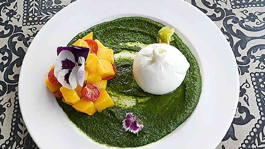 Mango Burrata Salad: An Instagrammable salad, this has fresh ripe mango chunks along with a big ripe blob of burrata cheese served with in-house basil pesto sauce.
