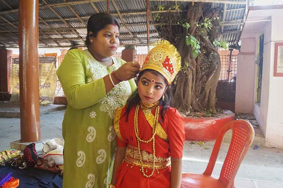 A girl dresses up as a goddess in Kalighat on the occasion of Gajan on Thursday  