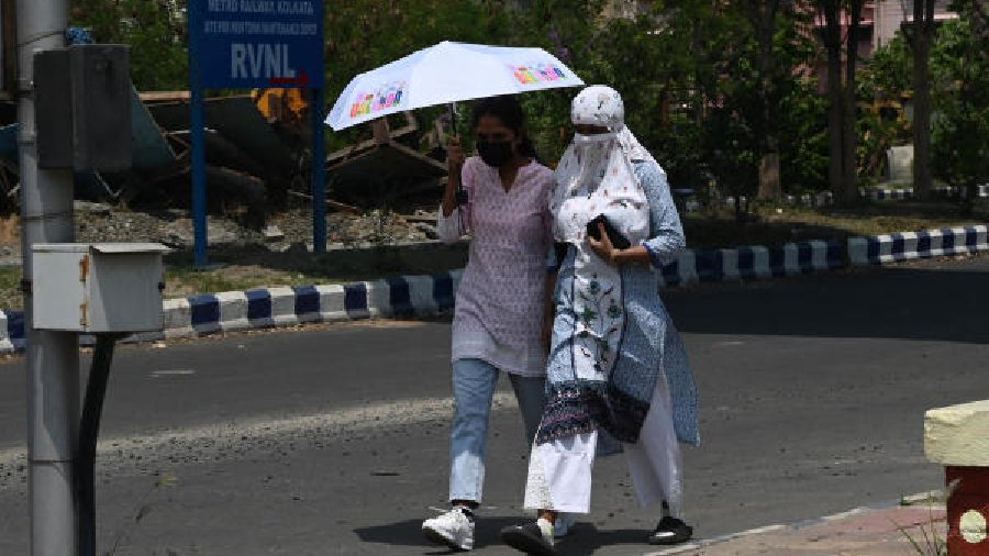 Pedestrians shield themselves against a scorching sun in New Town on Friday afternoon            
