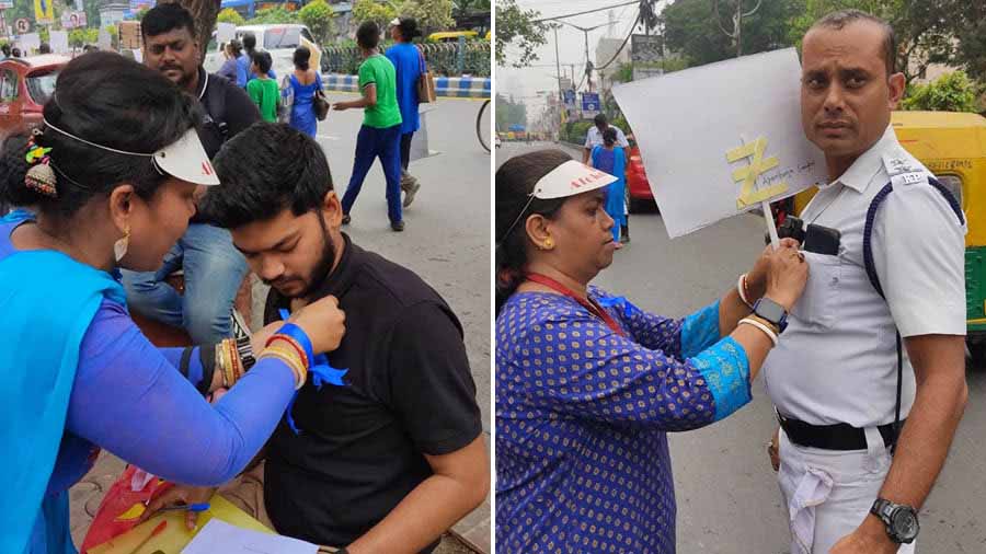 Alokdhara members tie blue ribbons on a traffic cop and an onlooker to create awareness about autism