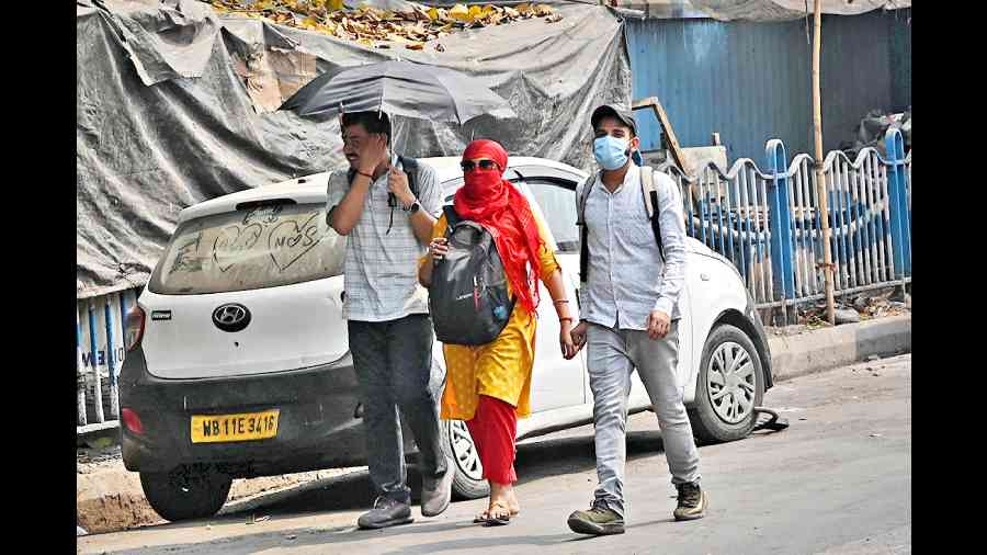 Pedestrians shield themselves from the sun in Sealdah on Tuesday afternoon.  