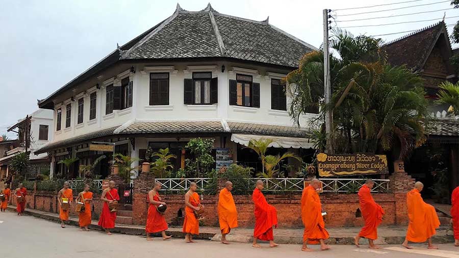 Laotian monks walk down the street during the alms-giving ceremony — an image that prompted the author’s visit to Luang Prabang 