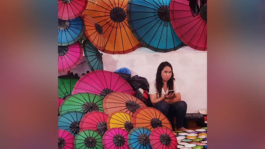 A woman sells umbrellas at the evening market 