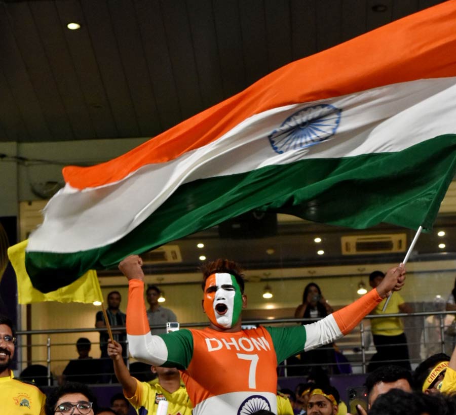 Body painted in the colours of the Indian flag with Dhoni written in bold, a man flutters the Tricolour in the Eden stands 