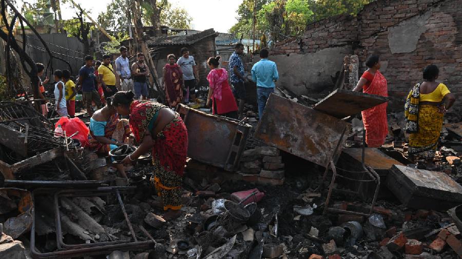 esidents search for belongings through the remains of their gutted homes in Duttabad on Monday