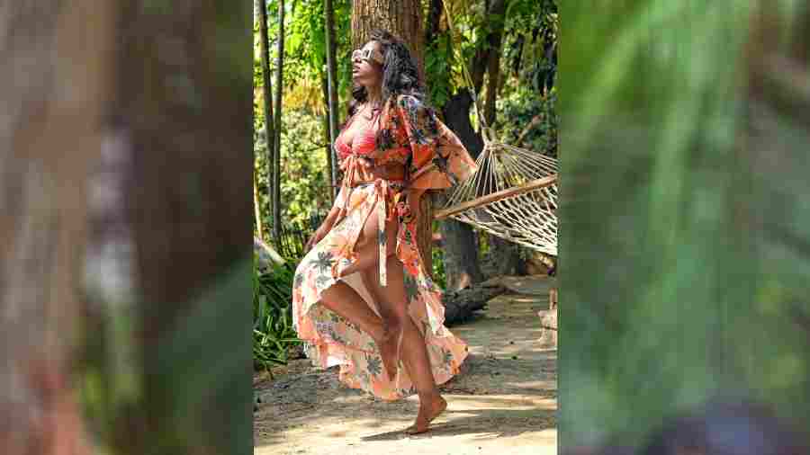 Megha channels beach vibes in her cover-up look. The vibrant florals, the hammock, the bare feet and the sun are what seaside holidays are made of.