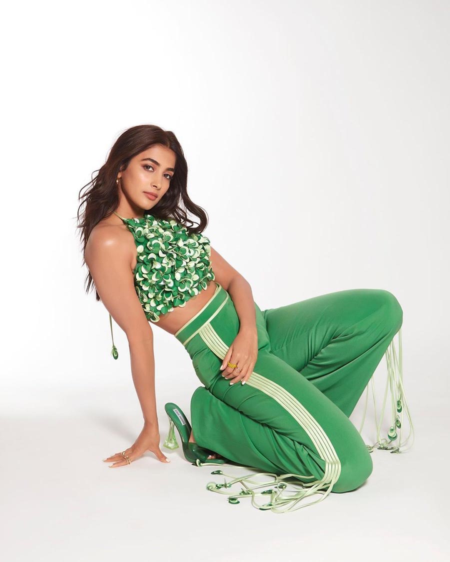 Acing a sporty yet stylish look, Pooja posed in a green halter neck crop top paired with matching trousers and heels. 