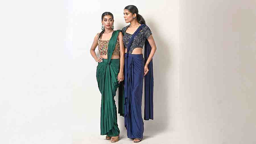 The brand has made its name for its predraped saris with flawless fall that accentuate any body type. The new collection features this dressy sari gown in the tranquil shade of midnight blue with tube sequin embellishments and an emerald and gold sari with a dainty blouse with charming colourful beads.