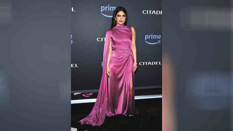 Statement-y yet chic was the buzzword for Priyanka at the Los Angeles red carpet. The pink floorsweeping gown by Roksanda fitted PC like a glove. The asymmetrical dress boasted a ruched waist with a knot, a modest slit, and an elegant cape draped down one arm, adding just the right amount of drama to the sleek ensemble.